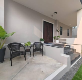 a patio with a table and chairs and a potted plant