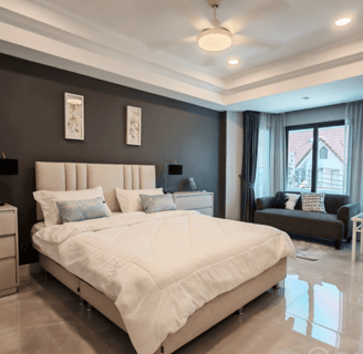 Primary bedroom with a bed and a couch. Thai Home for sale.