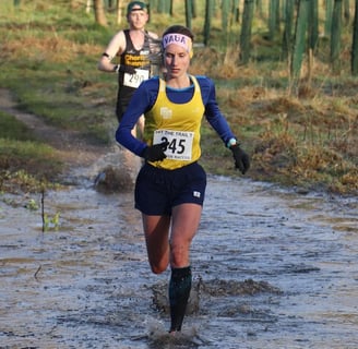a woman running in a muddy road