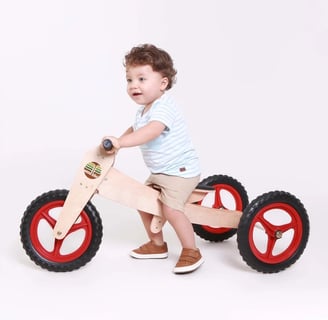 bebê em bicicleta de madeira