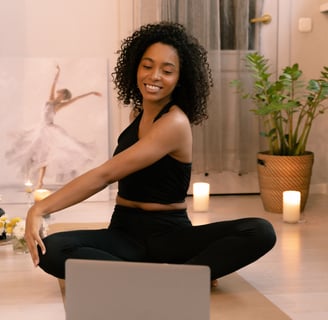 a woman sitting on a yoga mat with candles and candles engaging in virtual physiotherapy exercises