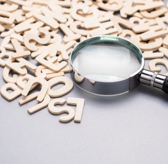 a magnifying glass amongst a jumble of letters