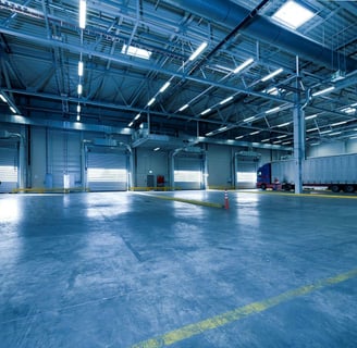 a large warehouse with a truck parked in the middle of the floor