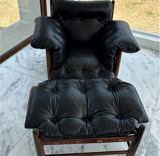 Uma poltrona elegante de couro na cor preta, totalmente restaurada e com brilho