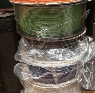 A selection of 3D printer filament reels in a range of colours