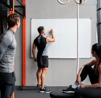 personal trainer writing workout plan on board