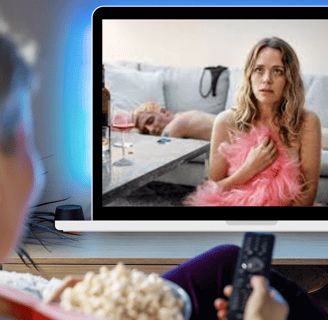 a woman watching a tv screen with a remote control
