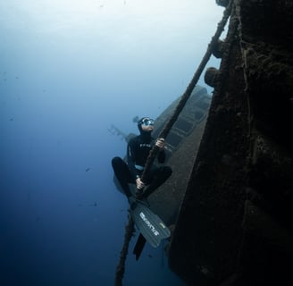 a freediver is holding a rope for an underwater photoshoot. Photo taken by Sébastien Saintignan
