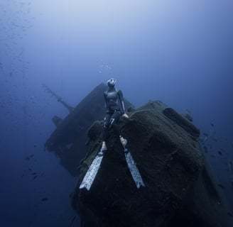 a freediver posing on top of a wreck ship. Photo taken by Sébastien Saintignan