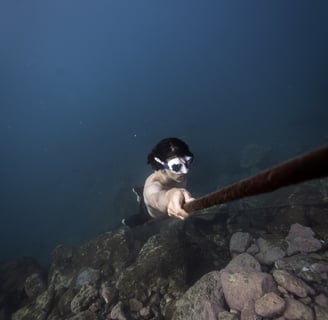 a model holding a rope during underwater photoshoot. Photo taken by Sébastien Saintignan