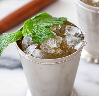 a cup of ice cream with mint tea and mint leaves