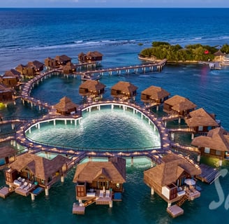 Coastal Vibe Travel - Sandals Weddings - a circular shaped fountain in the middle of a body of water
