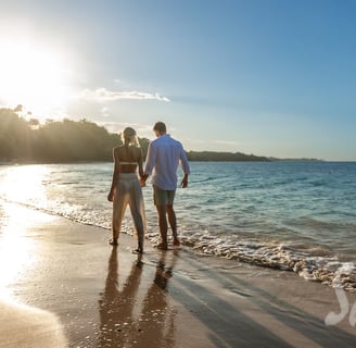 Coastal Vibe Travel - Sandals Honeymoons - a couple holding hands and walking on the beach
