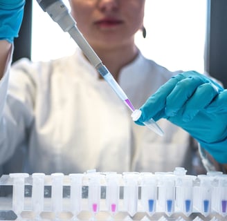 a woman in a lab coat and gloves holding a pipe of liquid