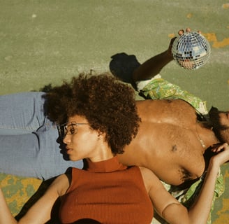 a man and woman laying on grass