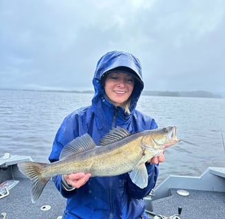 In Sweden, a female angler poses with her rainy day catch, a zander fish.