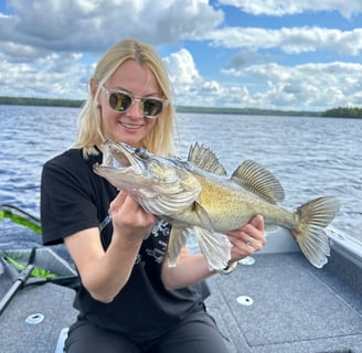 In Sweden, a female angler poses with a zander fish.