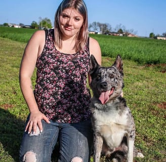 woman kneeling next to malincollie