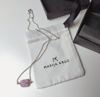 pakabukas su rausvu akmeniu šalia marija kruz vardinio maišelio