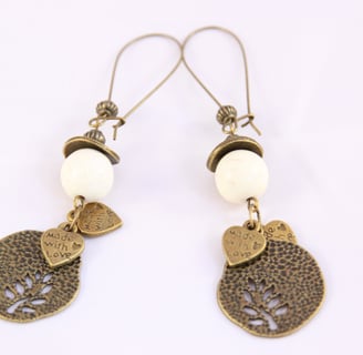 a pair of earrings with a bird on it