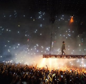 a man standing on a stage with a crowd of people