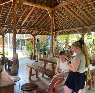 a group of people sitting at a table with a cell phone going for 7 days 6 nights Sunrise bali tours