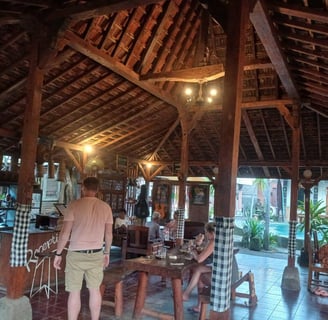a man and woman standing in a hut with a dog