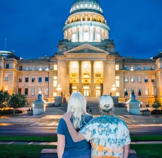 Couple standing in front of the Idaho state capital building at sundown.