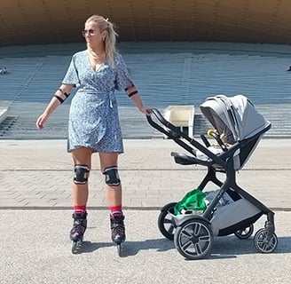 mama su vėžimėliu važinėja riedučiais Vingio parke