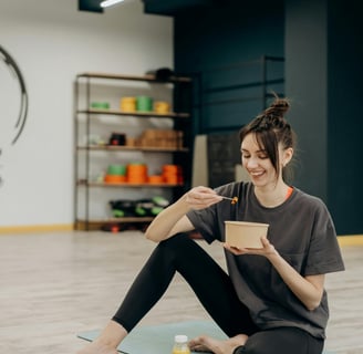 a woman sitting on a yoga mat with a tablet
