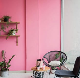 a pink room with a chair and a chair