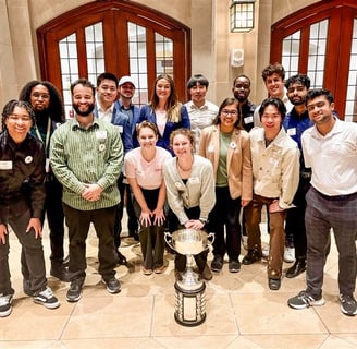 a group of skandalaris venture competition finalists standing around a trophy