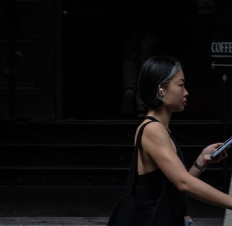 Young Asian Australian woman in gym gear walks along Sydney street