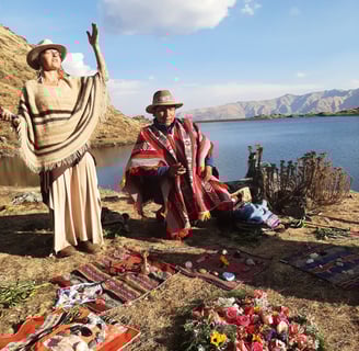a woman in a traditional dress and a man in a hat opening sacred space at a mountain lake