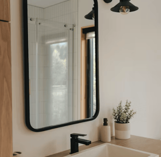 Miroir tendance noir dans salle de bain avec éclairage classique