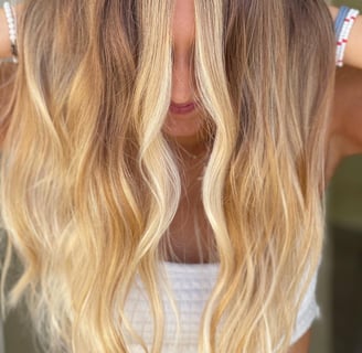 a woman with golden blonde hair, colored by hair by raqual rose