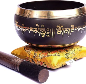 a singing himalayan bowl with a wooden stick 