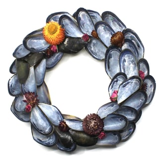 a wreath made of shells and shells with flowers