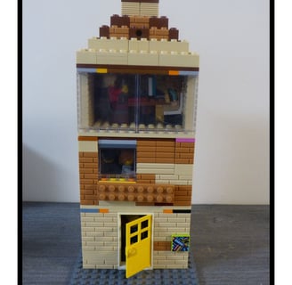 Casa rústica de tres pisos hecha con piezas de Lego.