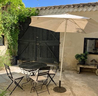 a patio table with chairs and umbrellas