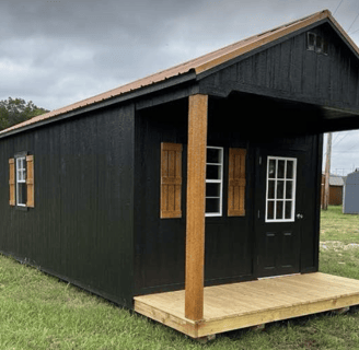 a small black cabin with a wooden deck and a wooden deck