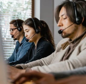 Contact center agents wearing headsets, working in a modern office environment.