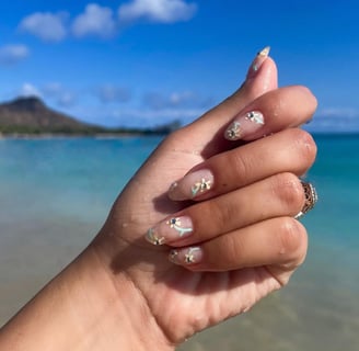 manicure with pale yellow flowers and greens stems and rhinestones for the flower center