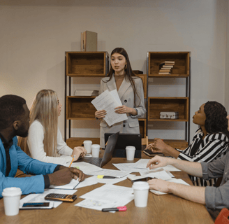une cheffe d'équipe explique sa vision du team building à son équipe de 4 personnes