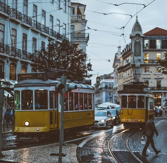 a yellow tram car is parked on the side of a street