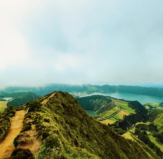 a person walking up a mountain with a view of a lake