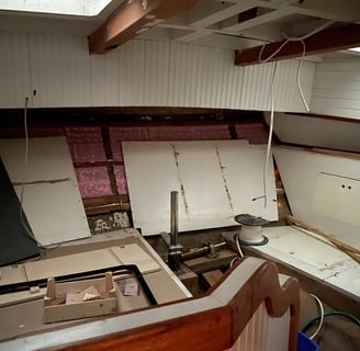 Aft state room with white panelling, the rudder post in the centre and storage on the side