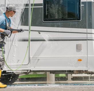 A man pressure washing an RV