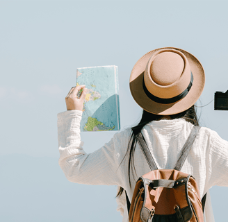 a woman in a hat and a backpacker holding a map