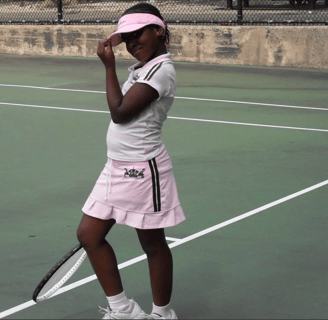 Image of Valicia Carmen at about 8 years old, on a tennis court in Brooklyn, NY